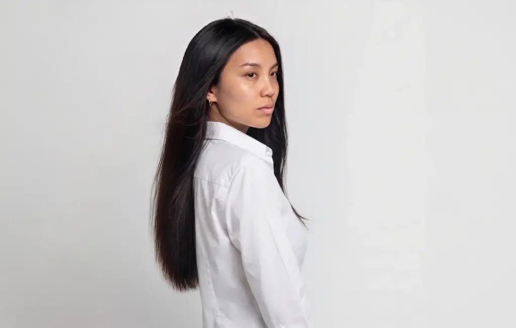 Digital twin de una modelo real con camisa blanca, creado con IA para el catálogo de una marca