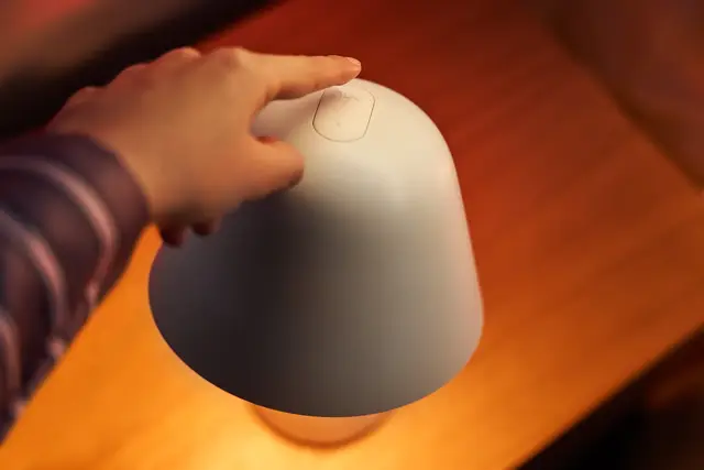 Mano encendiendo una lámpara Philips Hue