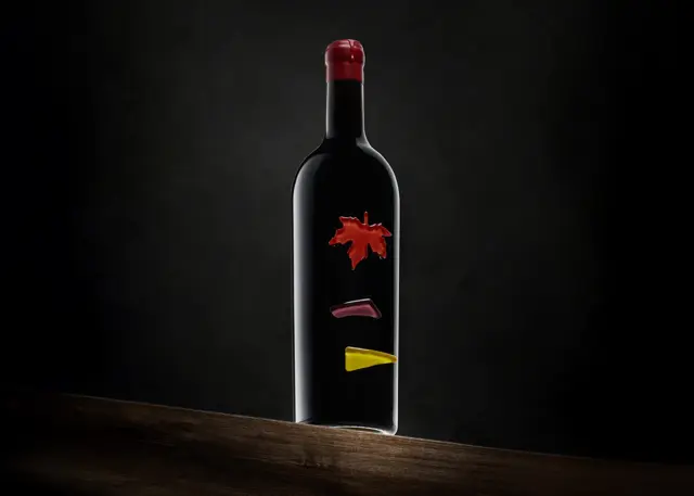 Botella de vino tinto sobre mesa oscura